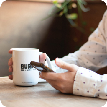 lady in white with coffee and mobile phone