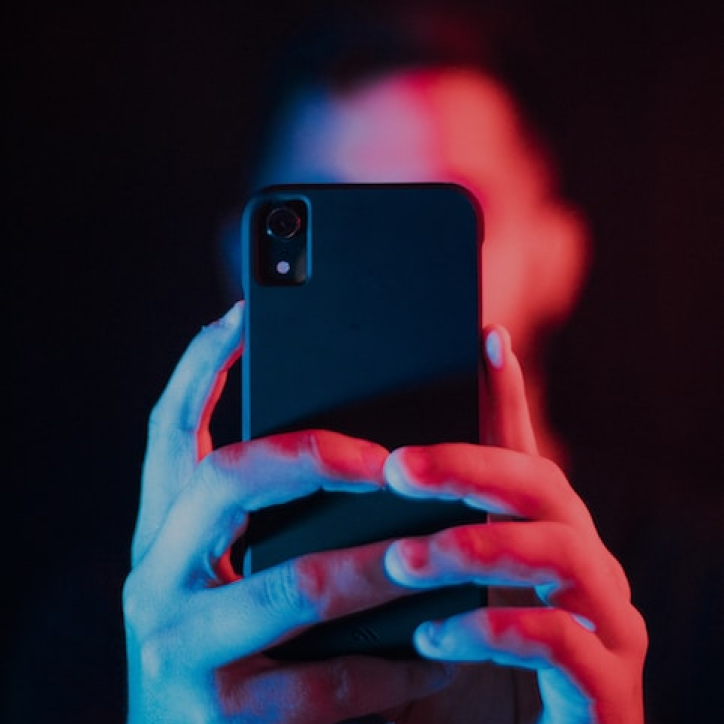 man holding up black phone